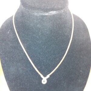 Gold tone chain necklace, with a rhinestone teardrop loop.